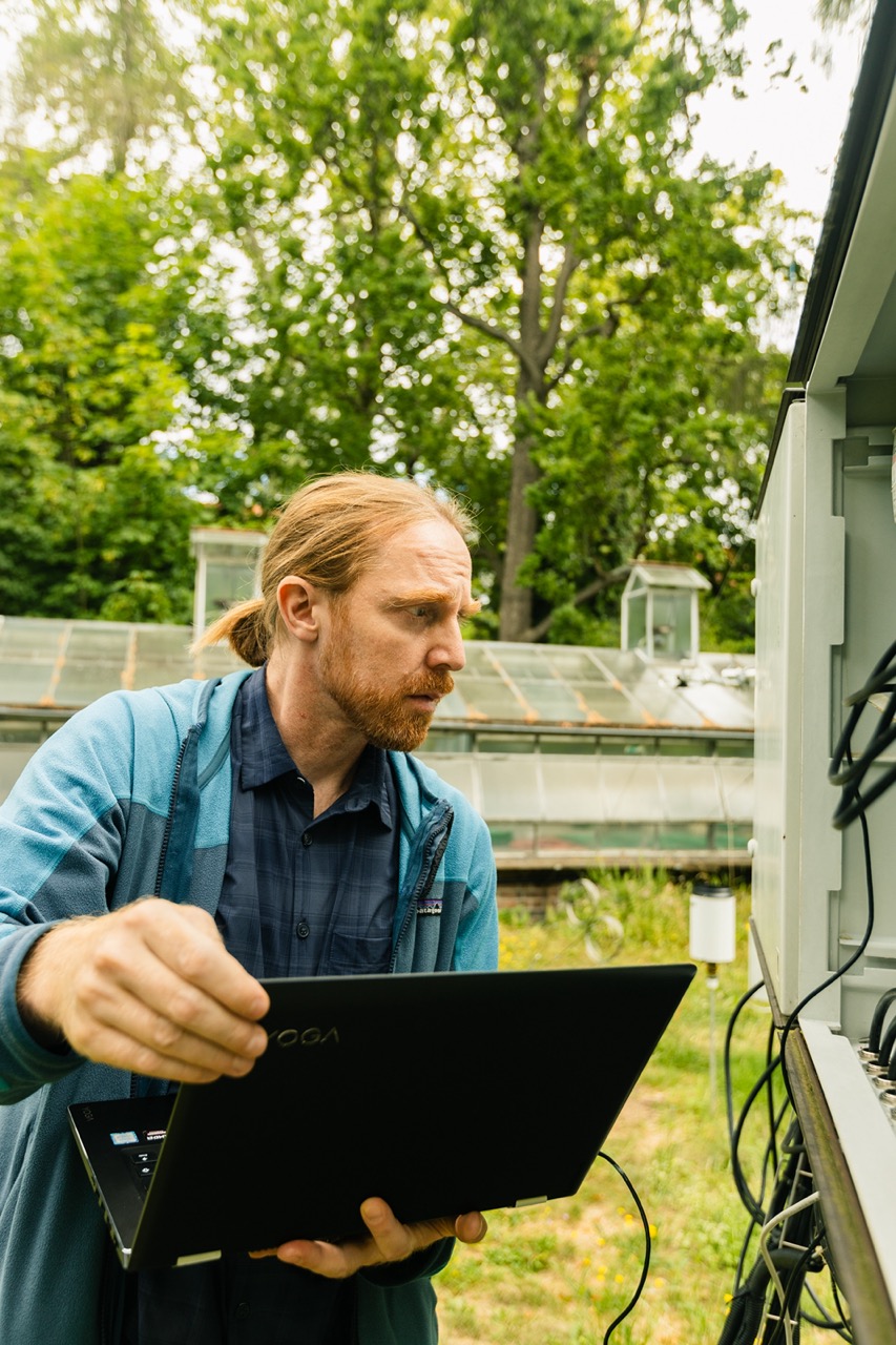 Station PI Fred Meier looking at the instrument with a laptop in his hands.