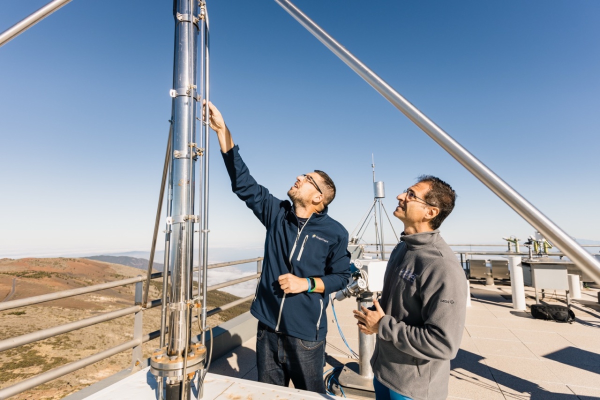 two scientists looking at instrumentation on a rooftop