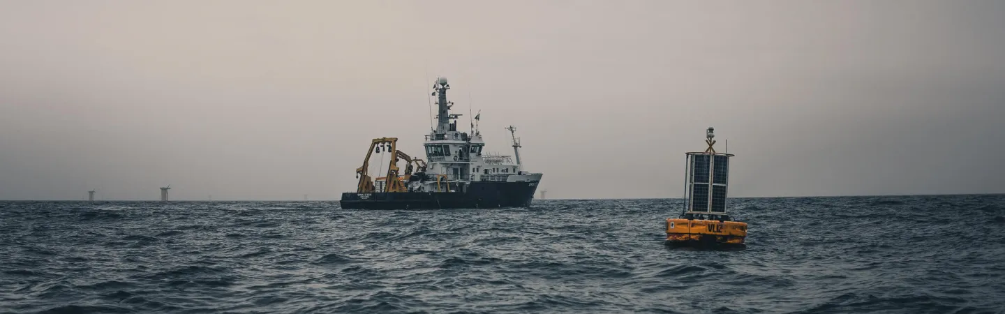 research vessel at sea with a yellow buoy on the foreground
